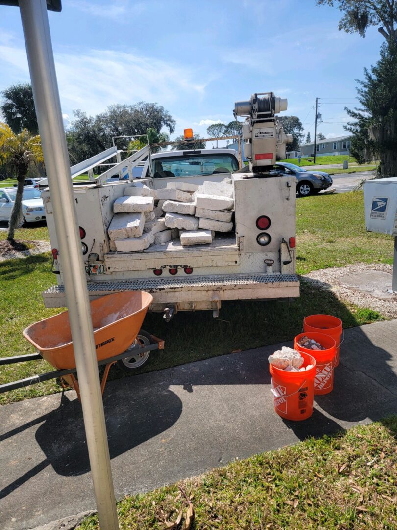 A utility truck parked next to a pole with buckets.