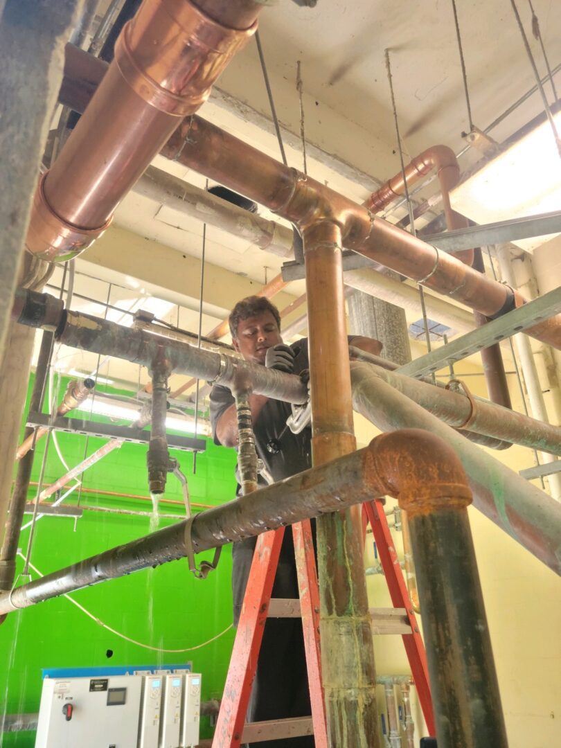 A man working on pipes in an industrial setting.